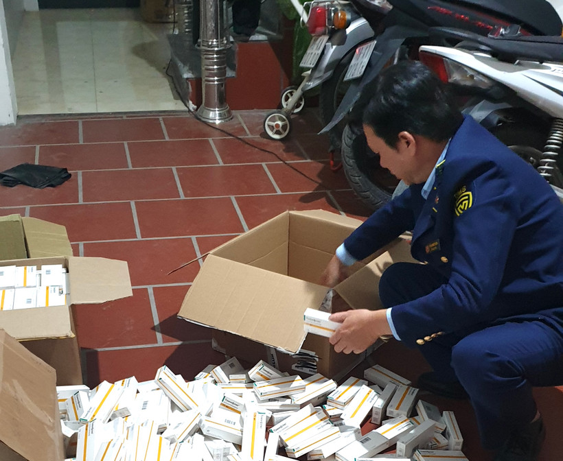 Cán bộ Đội Quản lý Thị trường số 1 kiểm tra thuốc nhãn Tamiflu có dấu hiệu vi phạm. (Ảnh: PV/Vietnam+)