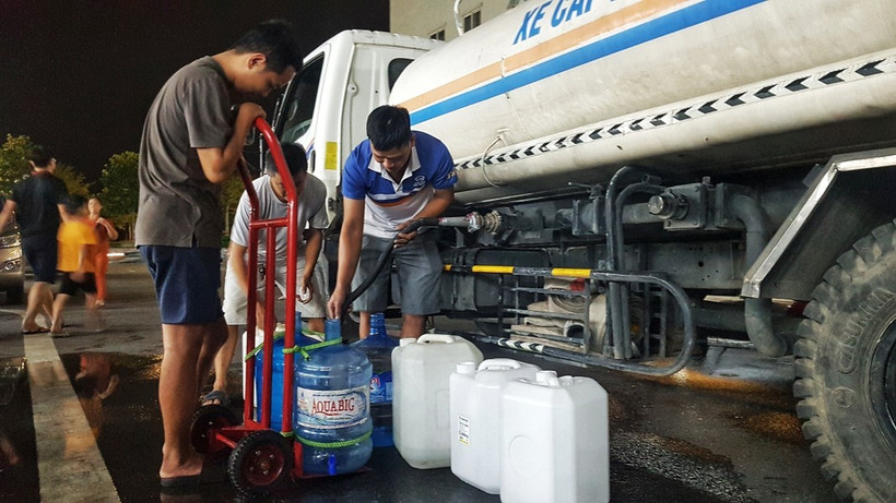 Người dân Khu Đô thị Thanh Hà lấy nước từ xe chở nước sạch. (Ảnh: Hoàng Hiếu/TTXVN)
