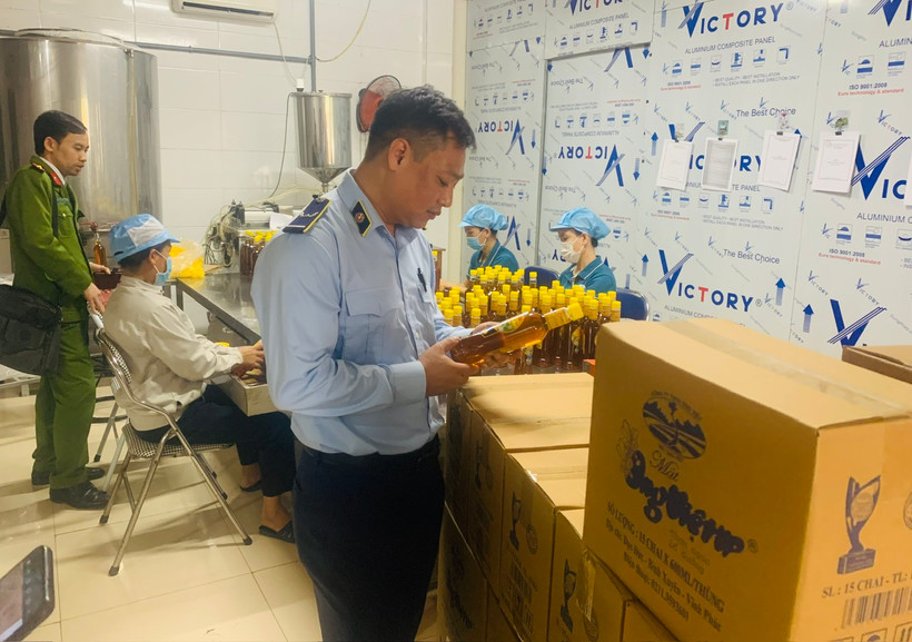 Lực lượng chức năng kiểm tra mật ong có dấu hiệu hàng giả. (Ảnh: PV/Vietnam+)