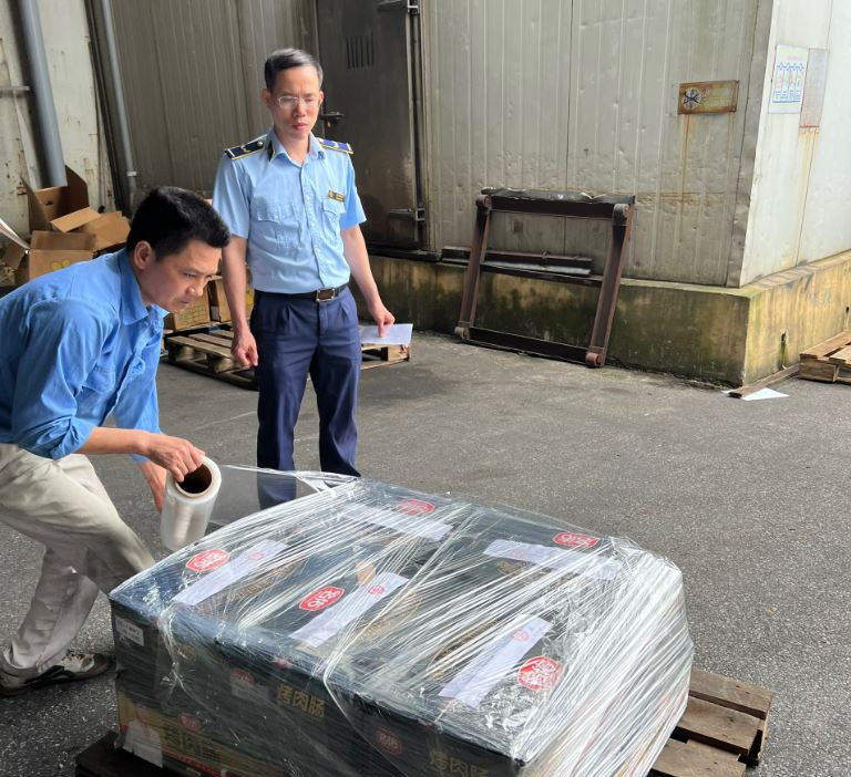 Đội Quản lý Thị trường số 17 kiểm tra xúc xích tại điểm tập kết hàng hóa tại huyện Thanh Trì. (Ảnh: PV/Vietnam+)