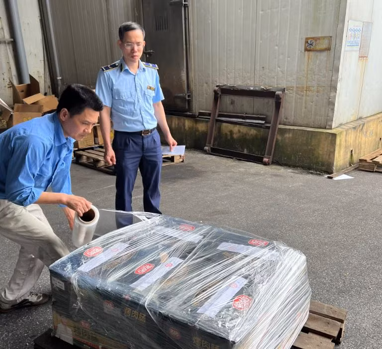 Đội Quản lý Thị trường số 17 kiểm tra xúc xích tại điểm tập kết hàng hóa tại huyện Thanh Trì. (Ảnh: PV/Vietnam+)