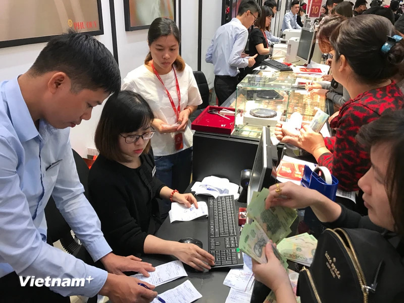 Khách hàng giao dịch vàng khu vực Hà Nội. (Ảnh: Đức Duy/Vietnam+)