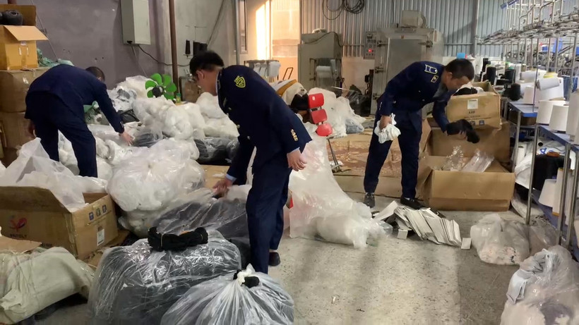 Lực lượng chức năng kiểm tra cơ sở nghi sản xuất bít tất giả nhãn hiệu được bảo hộ trên địa bàn huyện Đông Anh, Hà Nội. (Ảnh: PV/Vietnam+)