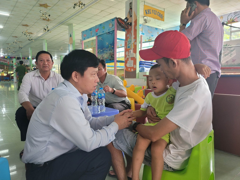 Tiến sỹ Lê Quang Trí, Giám đốc Sở Giáo dục và Đào tạo tỉnh Tiền Giang (trái) thăm hỏi cháu bé vừa được giải cứu. (Ảnh: Minh Trí/TTXVN)