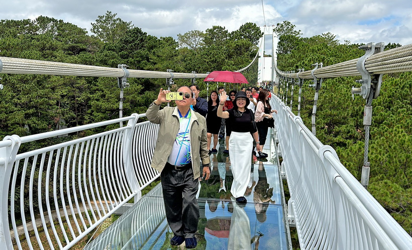 Du khách hào hứng tham quan, trải nghiệm Cầu kính Ngàn Thông tại Khu du lịch TTC Thung lũng Tình yêu, thành phố Đà Lạt. (Ảnh: Nguyễn Dũng/TTXVN) 