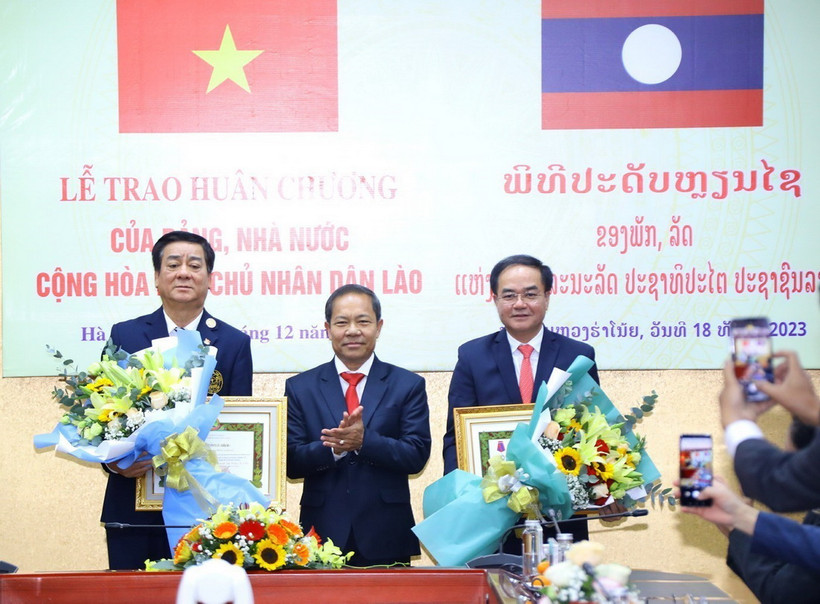 Ông Khamlay Sipraseuth, Uỷ viên Trung ương Đảng, Phó Chủ tịch thường trực Uỷ ban Trung ương Mặt trận Lào Xây dựng Đất nước trao tặng Huân chương Itxala (Tự do) hạng III cho Thứ trưởng Bộ Nội vụ Vũ Chiến Thắng (bên phải) và nguyên Thứ trưởng, nguyên Phó Chủ nhiệm Ủy ban Dân tộc Hoàng Xuân Lương (bên trái). (Ảnh: Văn Điệp/TTXVN)