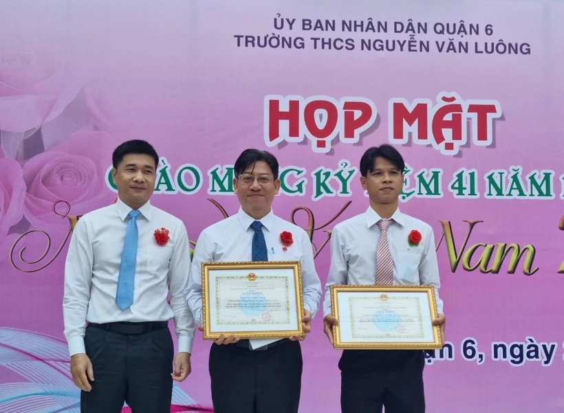 Lãnh đạo Bảo hiểm xã hội Thành phố Hồ Chí Minh tuyên dương, khen thưởng thầy hiệu trưởng và tập thể giáo viên Trường THCS Nguyễn Văn Luông, Quận 6. (Ảnh: TTXVN phát)