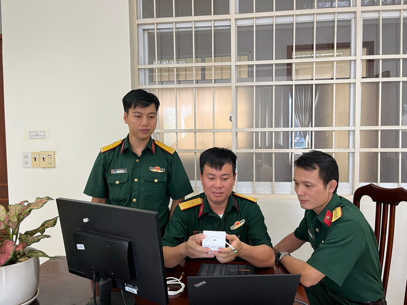 Thiếu tá Thiều Hữu Cường (ngồi giữa) với thiết bị IoT cảnh báo nguy cơ đột quỵ. (Ảnh: TTXVN phát)