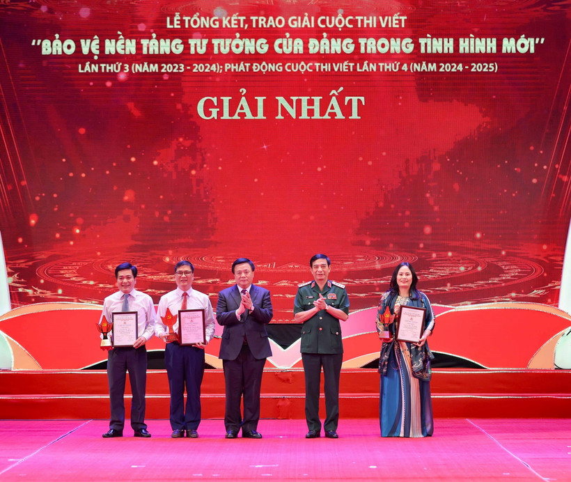 Đại tướng Phan Văn Giang, Ủy viên Bộ Chính trị, Bộ trưởng Bộ Quốc phòng và đồng chí Nguyễn Xuân Thắng, Ủy viên Bộ Chính trị, Chủ tịch Hội đồng Lý luận Trung ương, Giám đốc Học viện Chính trị Quốc gia Hồ Chí Minh trao giải cho các tác giả, nhóm tác giả đoạt giải Nhất. (Ảnh: Thanh Tùng/TTXVN)