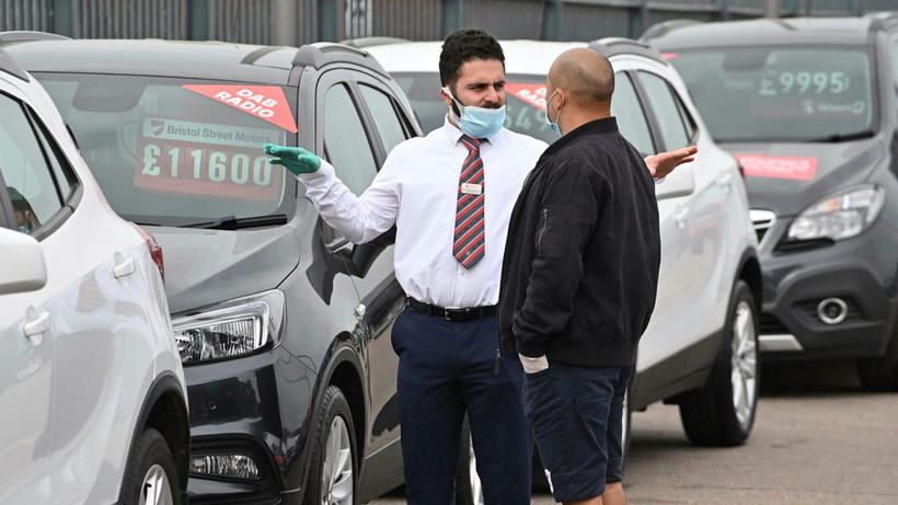 Nhân viên giới thiệu khách tới mua xe tại London, Anh. (Nguồn: AFP)