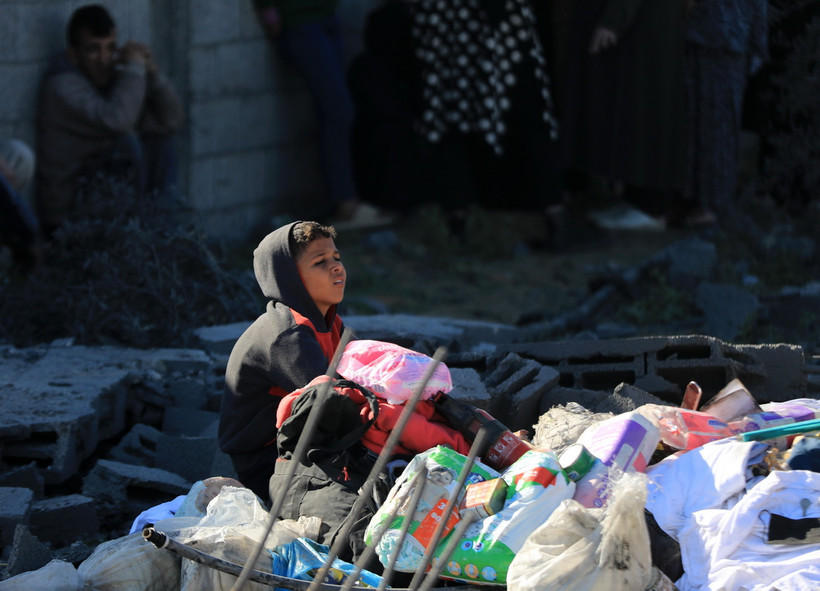 Một em nhỏ Palestine ngồi giữa đống đổ nát sau cuộc oanh kích của Israel xuống thành phố Rafah, Dải Gaza, ngày 7/1/2024. (Ảnh: THX/TTXVN)