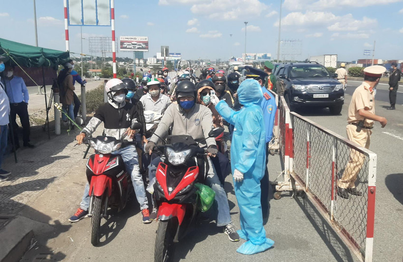 Nhân viên y tế đo thân nhiệt tại chốt kiểm dịch. (Ảnh: Đinh Hằng/TTXVN)