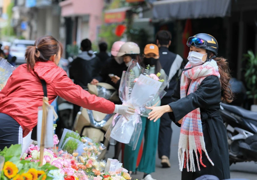 Người dân trang bị áo ấm, khăn len để tránh rét. (Ảnh: Hoàng Hiếu/TTXVN)