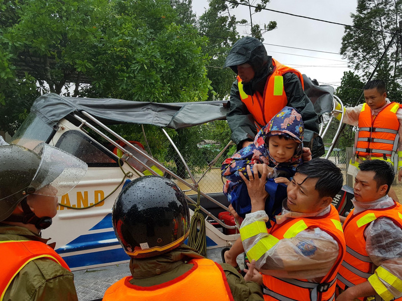 Di chuyển người dân ra khỏi khu vực ngập lũ tại huyện Cam Lộ. (Ảnh: Thanh Thủy/TTXVN)
