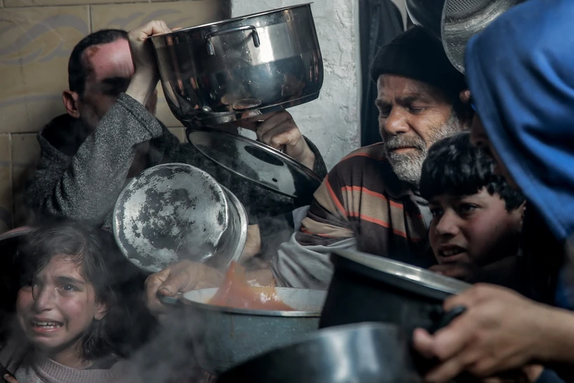 Người dân Palestine chờ nhận thực phẩm cứu trợ tại Beit Lahia, phía Bắc Dải Gaza, ngày 26/2/2024. (Ảnh: AFP/TTXVN)