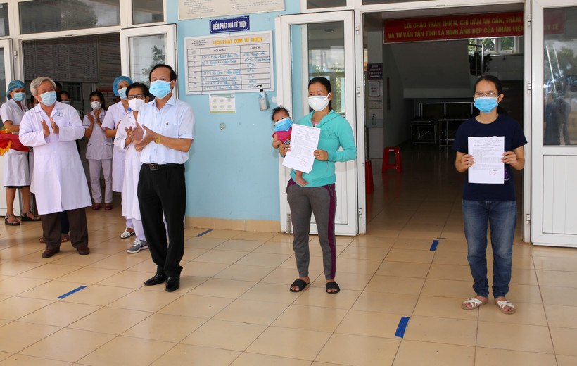 Lãnh đạo Sở Y tế Quảng Trị trao giấy xác nhận hoàn thành thời gian cách ly y tế phòng, chống dịch COVID-19 cho 2 bệnh nhân. (Ảnh: Hồ Cầu/TTXVN)