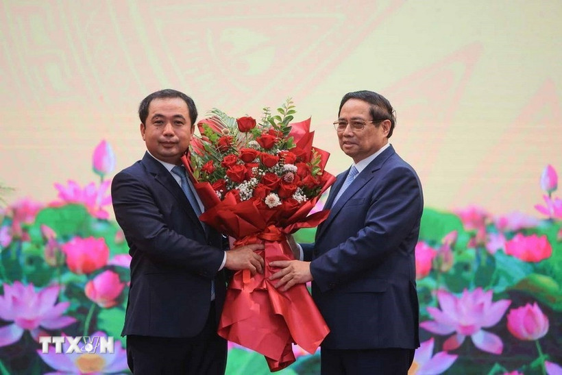 Thủ tướng Phạm Minh Chính tặng hoa chúc mừng quyền Bộ trưởng Bộ Nông nghiệp và Môi trường Trần Đức Thắng. (Ảnh: Hoàng Hiếu/TTXVN)