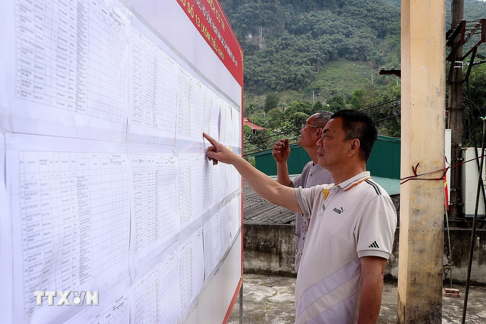 Cử tri điểm cảng Bích Hạ, phường Tân Hòa tích cực nghiên cứu danh sách đại biểu. (Ảnh: Thanh Hải/TTXVN)