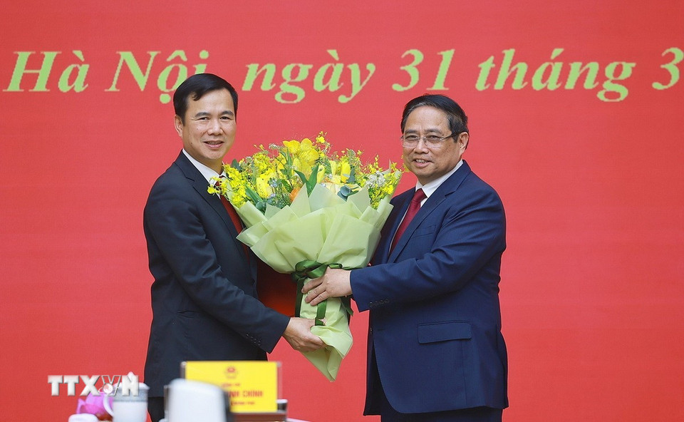 Thủ tướng Phạm Minh Chính tặng hoa chúc mừng ông Bùi Thế Duy giữ chức Giám đốc Đại học Quốc gia Hà Nội. (Ảnh: Dương Giang/TTXVN)