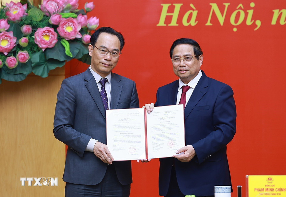 Thủ tướng Phạm Minh Chính trao Quyết định của Thủ tướng Chính phủ về việc điều động ông Hoàng Minh Sơn, Giám đốc Đại học Quốc gia Hà Nội, về công tác tại Bộ Giáo dục và Đào tạo, giao Quyền Bộ trưởng Bộ Giáo dục và Đào tạo. (Ảnh: Dương Giang/TTXVN)