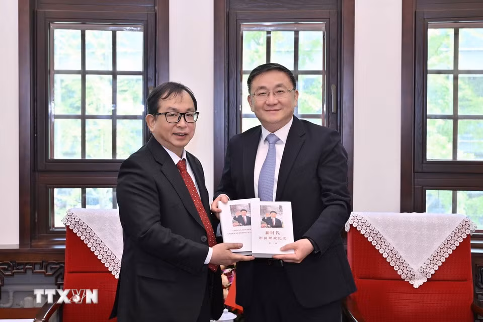 Phó Tổng Giám đốc TTXVN Nguyễn Tuấn Hùng (trái) và đồng chí Nhậm Vệ Đông, Ủy viên Ban Cán sự Đảng, Phó Tổng Biên tập Tân Hoa xã tại buổi làm việc. (Ảnh: THX/TTXVN phát)