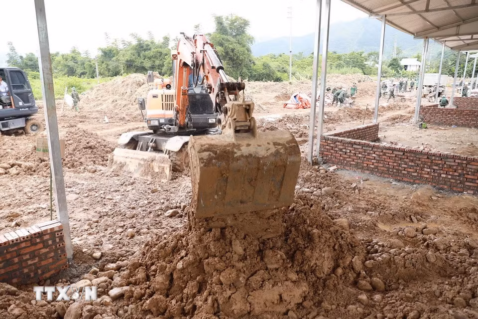 Máy xúc san gạt nền, móng nhà làm việc liên tục để đẩy nhanh tiến độ, góp phần sớm hoàn thành những căn nhà cho người dân vùng lũ Mường Than. (Ảnh: Quý Trung/TTXVN)