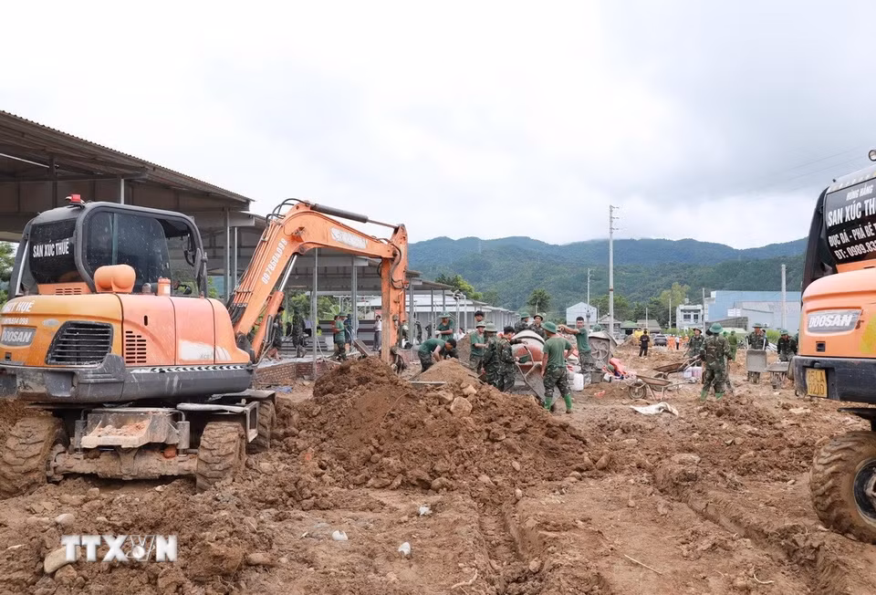 Máy xúc san gạt nền nhà thi công tại bản Sân Bay, xã Mường Than. (Ảnh: Quý Trung/TTXVN)