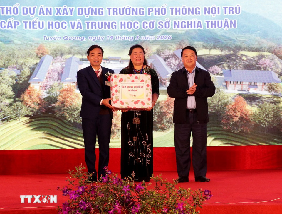 Ông Hầu A Lềnh, Bí thư Tỉnh ủy Tuyên Quang, tặng quà cho đại diện Ban giám hiệu trường Phổ thông Dân tộc nội trú liên cấp Tiểu học và Trung học cơ sở Nghĩa Thuận. (Ảnh: Đức Thọ/TTXVN)
