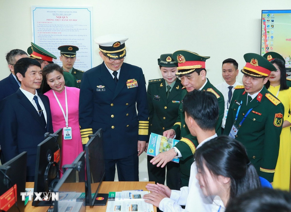 Bộ trưởng Quốc phòng Phan Văn Giang và Bộ trưởng Quốc phòng Trung Quốc Đổng Quân tham quan các phòng học vi tính của trường THPT Trần Phú. (Ảnh: Trọng Đức/TTXVN)