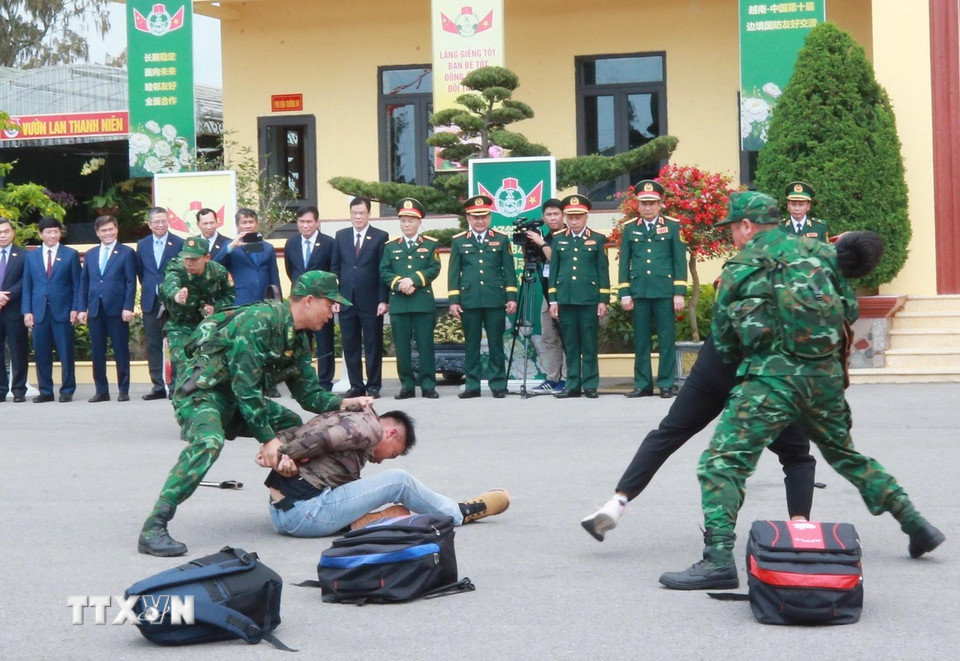 Bộ trưởng Quốc phòng Phan Văn Giang và Bộ trưởng Quốc phòng Trung Quốc Đổng Quân cùng các đại biểu xem diễn tập đánh bắt tội phạm ma túy của chiến sỹ Đồn Biên phòng Trà Cổ. (Ảnh: Trọng Đức/TTXVN)