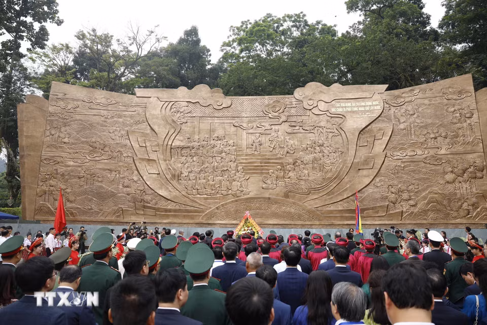 Tổng Bí thư, Chủ tịch nước Tô Lâm và các đại biểu dâng hoa tại Bức phù điêu "Bác Hồ nói chuyện với cán bộ, chiến sỹ Đại đoàn quân Tiên Phong." (Ảnh: Thống Nhất/TTXVN)