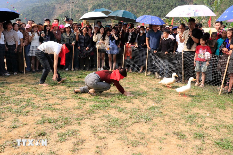 Người dân và du khách tham gia trò chơi bịt mắt bắt vịt. (Ảnh: Đinh Thùy/TTXVN)