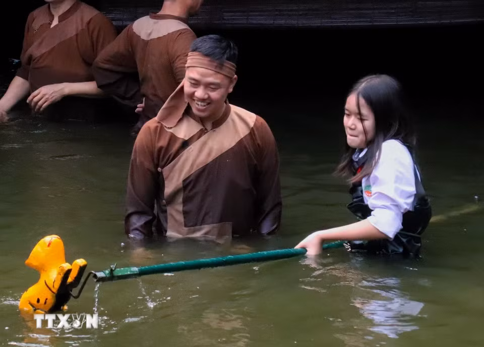 Hào hứng khi trực tiếp điều khiển rối dưới sự hướng dẫn tận tình của các nghệ nhân. (Ảnh: Phương Anh/TTXVN phát)