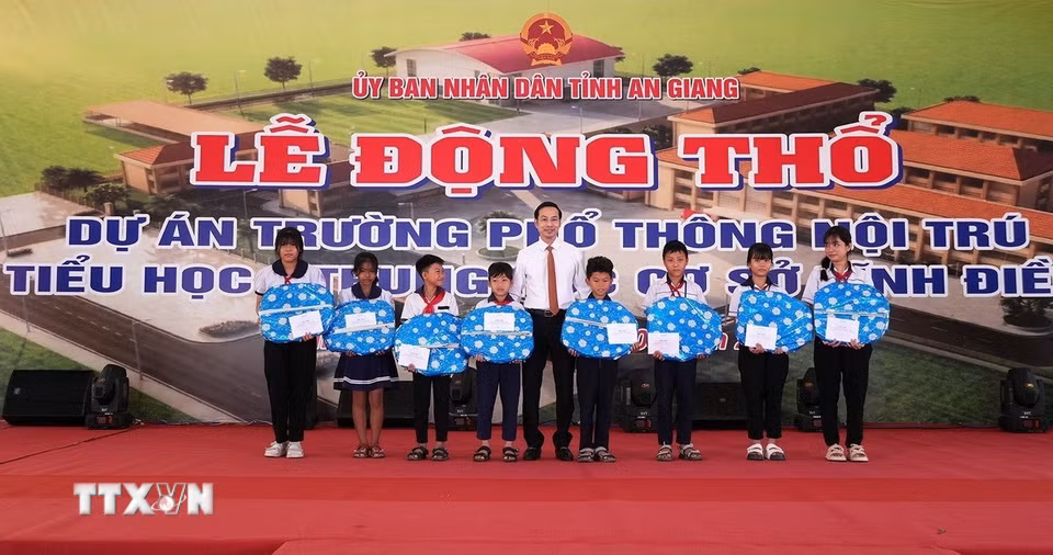 Lãnh đạo tỉnh An Giang tặng quà cho học sinh hoàn cảnh khó khăn. (Ảnh: Lê Huy Hải/TTXVN)