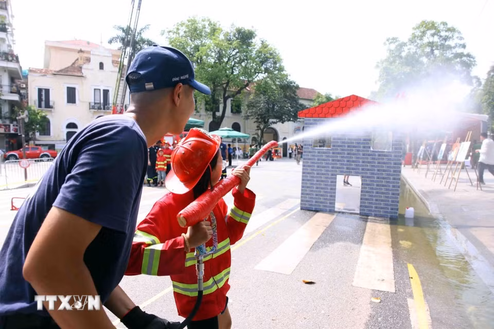 Các em nhỏ thích thú được trải nghiệm làm lính cứu hỏa. (Ảnh: Phạm Kiên/TTXVN)