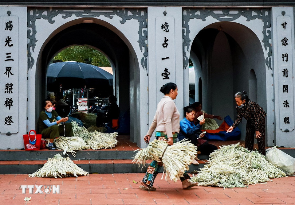 Phía ngoài sân chùa là nơi bày bán lá lụi, nguyên liệu chính để làm nón Chuông. (Ảnh: Vân Chi/TTXVN phát)