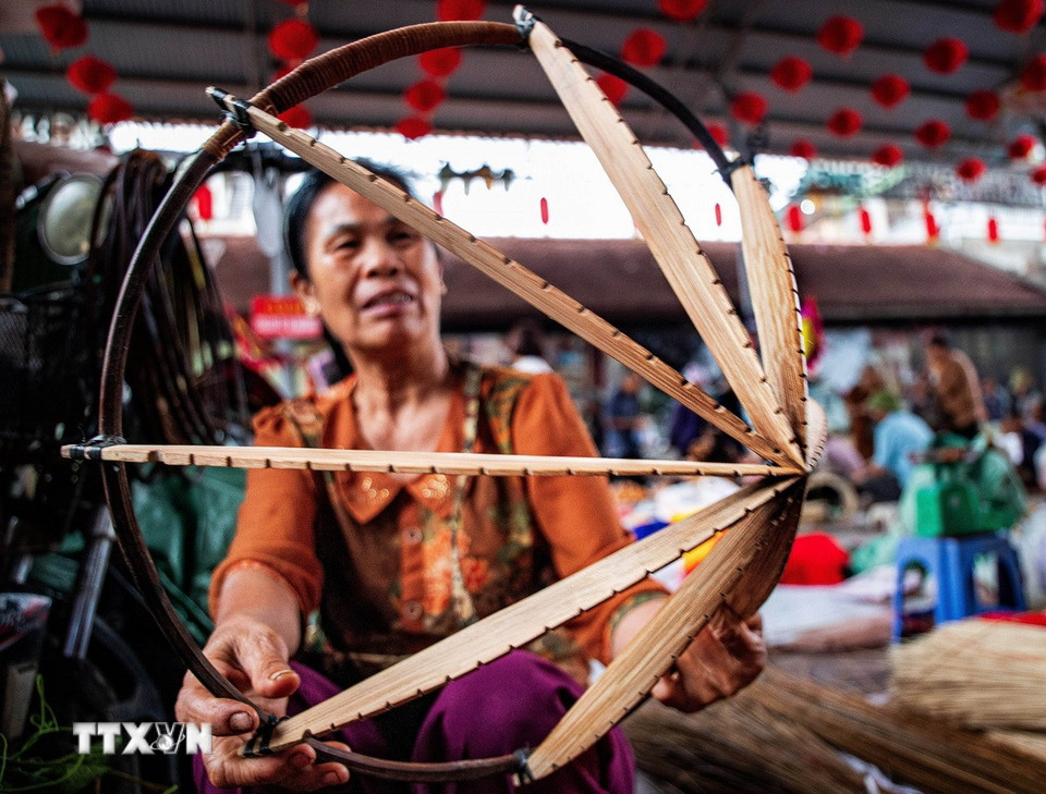 Từ khung nón ban đầu, người thợ lần lượt thực hiện nhiều công đoạn như xử lý lá, vức vòng, quay nón, khâu nón, lồng nhôi, cạp nón… để làm nên một chiếc nón hoàn chỉnh. (Ảnh: Vân Chi/TTXVN phát)