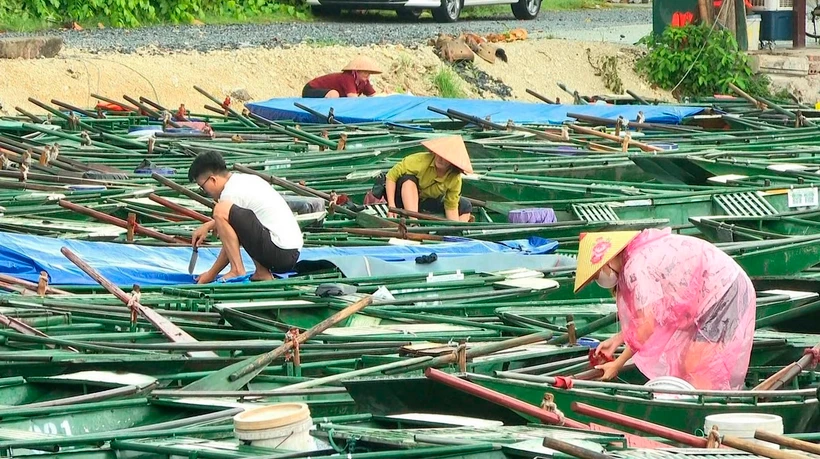 Lái đò Khu du lịch Tam Cốc-Bích Động, huyện Hoa Lư, tỉnh Ninh Bình chằng chống thuyền ứng phó với bão số 3. (Ảnh: Thùy Dung-TTXVN)