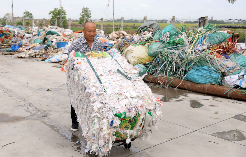 Anh Trần Văn Toàn (xã Tây Lương, huyện Tiền Hải) tất bật với công việc ở xưởng thu gom, tái chế bao bì để kịp xuất hàng cho khách. (Nguồn: Vietnam+)