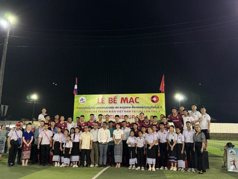 Các cầu thủ chụp ảnh chung với những người khuyết tật tại thủ đô Vientiane được nhận quà hỗ trợ. (Ảnh: TTXVN phát)