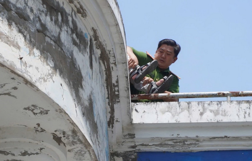 Lực lượng Công an giải cứu nam sinh muốn nhảy lầu trên sân thượng của nhà sách Phương Nam. (Ảnh: TTXVN phát)