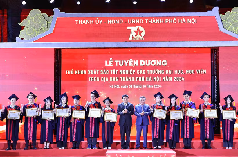 Ông Nguyễn Đắc Vinh, Ủy viên Trung ương Đảng, Chủ nhiệm Ủy ban Văn hóa, Giáo dục của Quốc hội và ông Nguyễn Văn Phong, Phó Bí thư Thành ủy Hà Nội trao Bằng khen của Chủ tịch Ủy ban Nhân dân Thành phố cho các thủ khoa xuất sắc tiêu biểu. (Ảnh: Minh Đức/TTXVN)