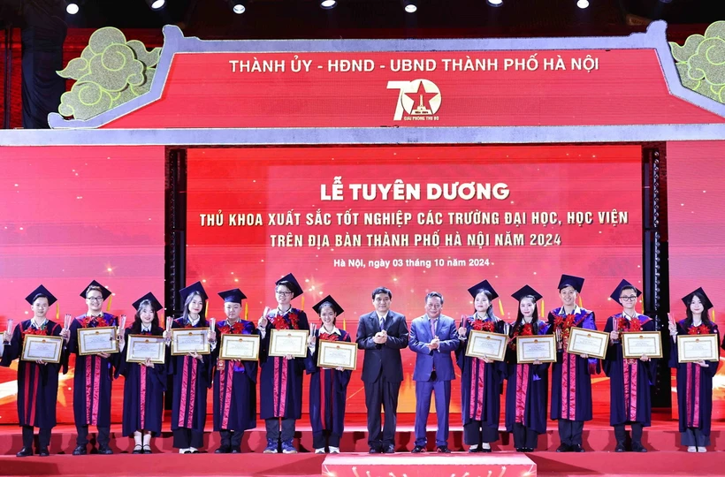 Ông Nguyễn Đắc Vinh, Ủy viên Trung ương Đảng, Chủ nhiệm Ủy ban Văn hóa, Giáo dục của Quốc hội và ông Nguyễn Văn Phong, Phó Bí thư Thành ủy Hà Nội trao Bằng khen của Chủ tịch Ủy ban Nhân dân Thành phố cho các thủ khoa xuất sắc tiêu biểu. (Ảnh: Minh Đức/TTXVN)