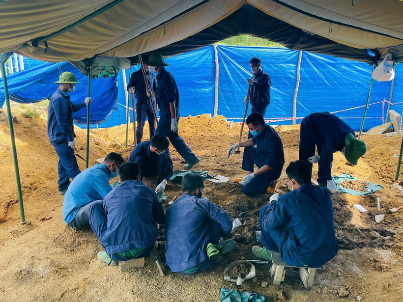 Lực lượng chức năng thực hiện quy trình quy tập hài cốt liệt sỹ. (Ảnh: TTXVN phát)