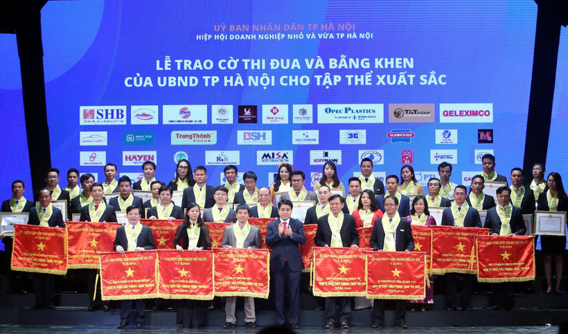 Chủ tịch Ủy ban Nhân dân thành phố Hà Nội Nguyễn Đức Chung trao bằng khen của thành phố cho các doanh nghiệp đạt thành tích xuất sắc. (Ảnh: Danh Lam/TTXVN) 