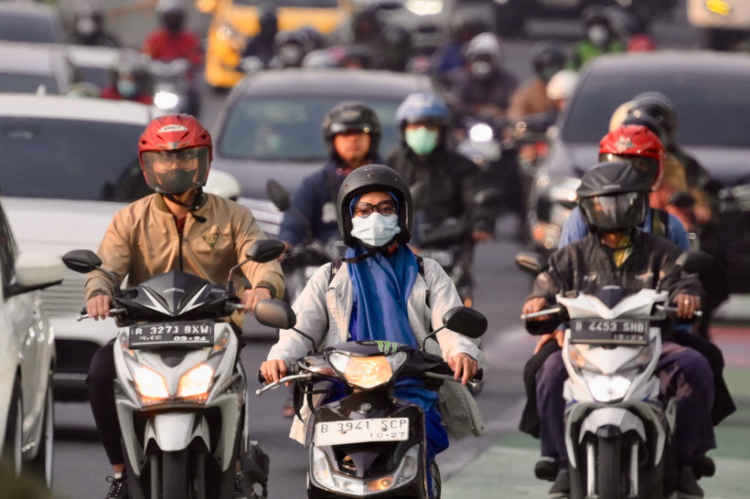 Người dân đeo khẩu trang tránh khói bụi trên một tuyến đường ở Jakarta, Indonesia. (Ảnh: AFP/TTXVN)