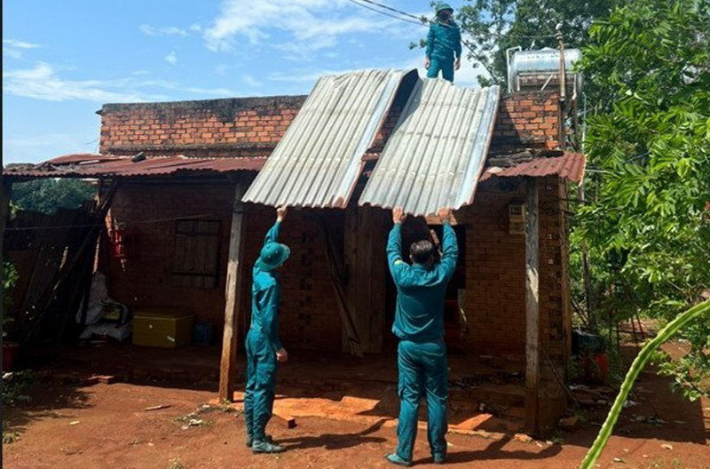 Lực lượng dân quân hỗ trợ người dân khắc phục hậu quả lốc xoáy. (Ảnh: TTXVN phát)