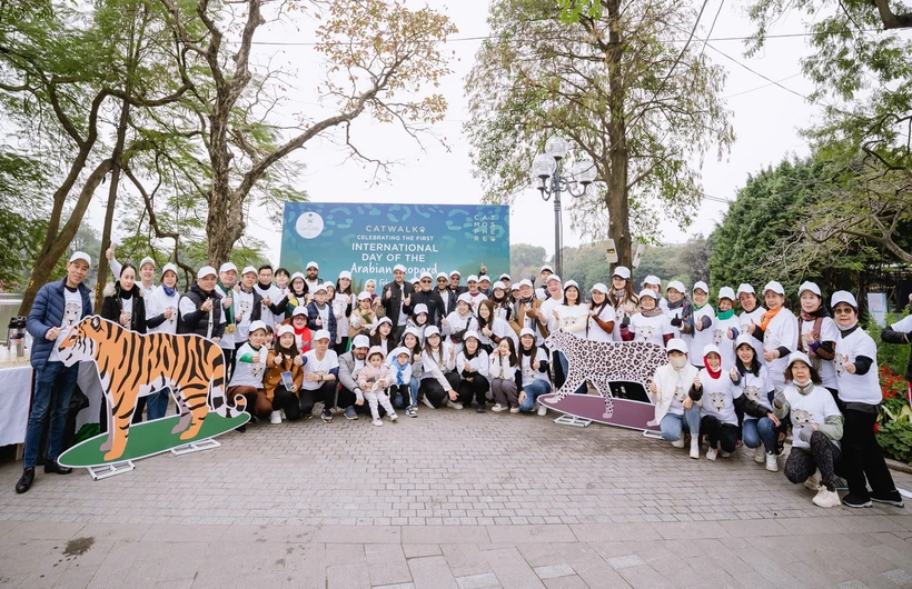 Các nhà ngoại giao quốc tế và gia đình tham gia chương trình đi bộ bên Hồ Hoàn Kiếm kêu gọi bảo tồn thú họ Mèo. (Ảnh: TTXVN phát)