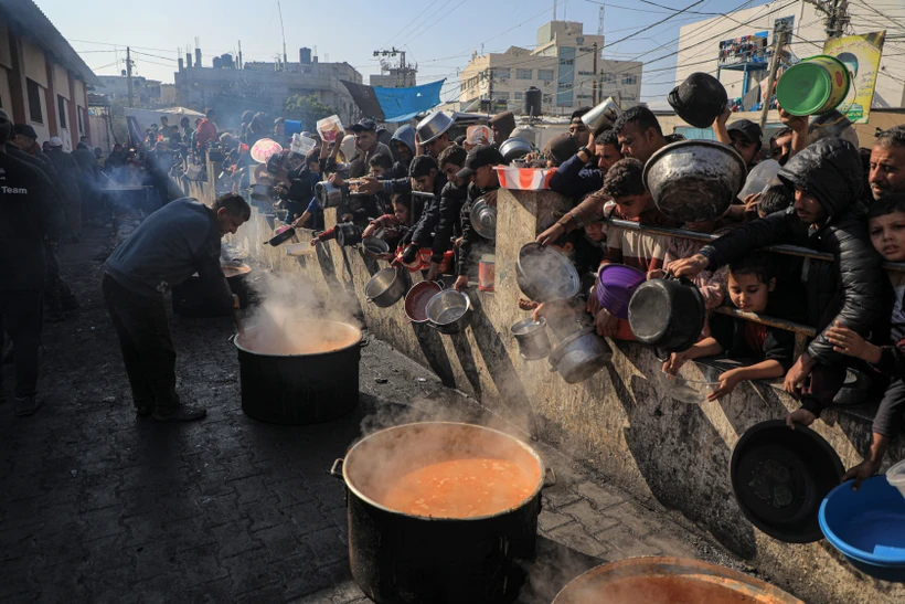 Người dân chờ nhận thực phẩm cứu trợ tại thành phố Rafah, phía Nam Dải Gaza ngày 31/12/2023. (Ảnh: THX/TTXVN)