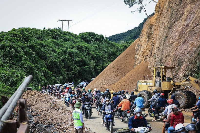 Người và phương tiện giao thông di chuyển chậm nối nhau đi qua điểm sạt lở tại dốc Cun, Km79+335, Quốc lộ 6, thuộc địa phận phường Thống Nhất, thành phố Hòa Bình. (Ảnh: Trọng Đạt/TTXVN)